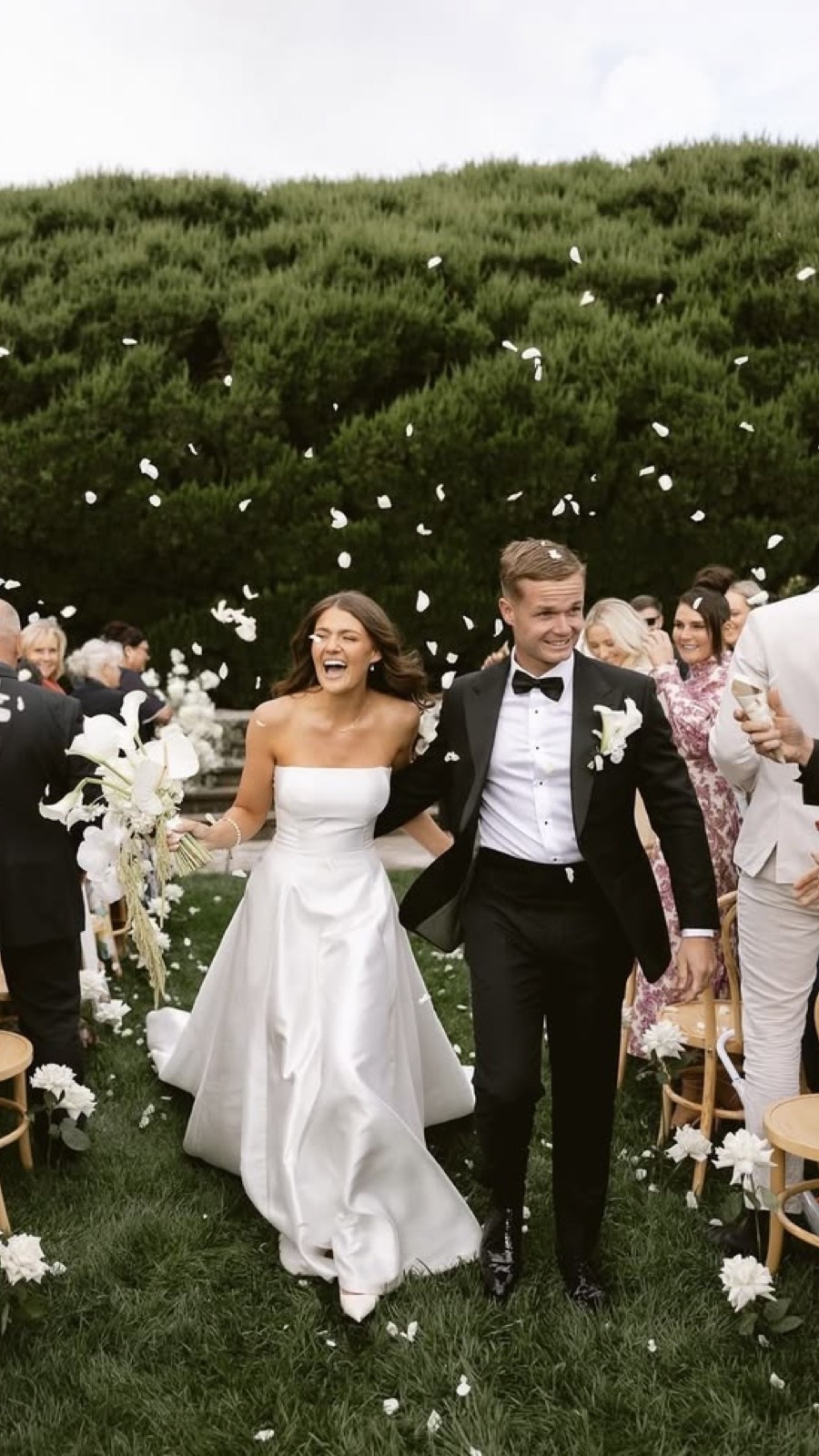 Confetti falling as the couple walks past their guests.